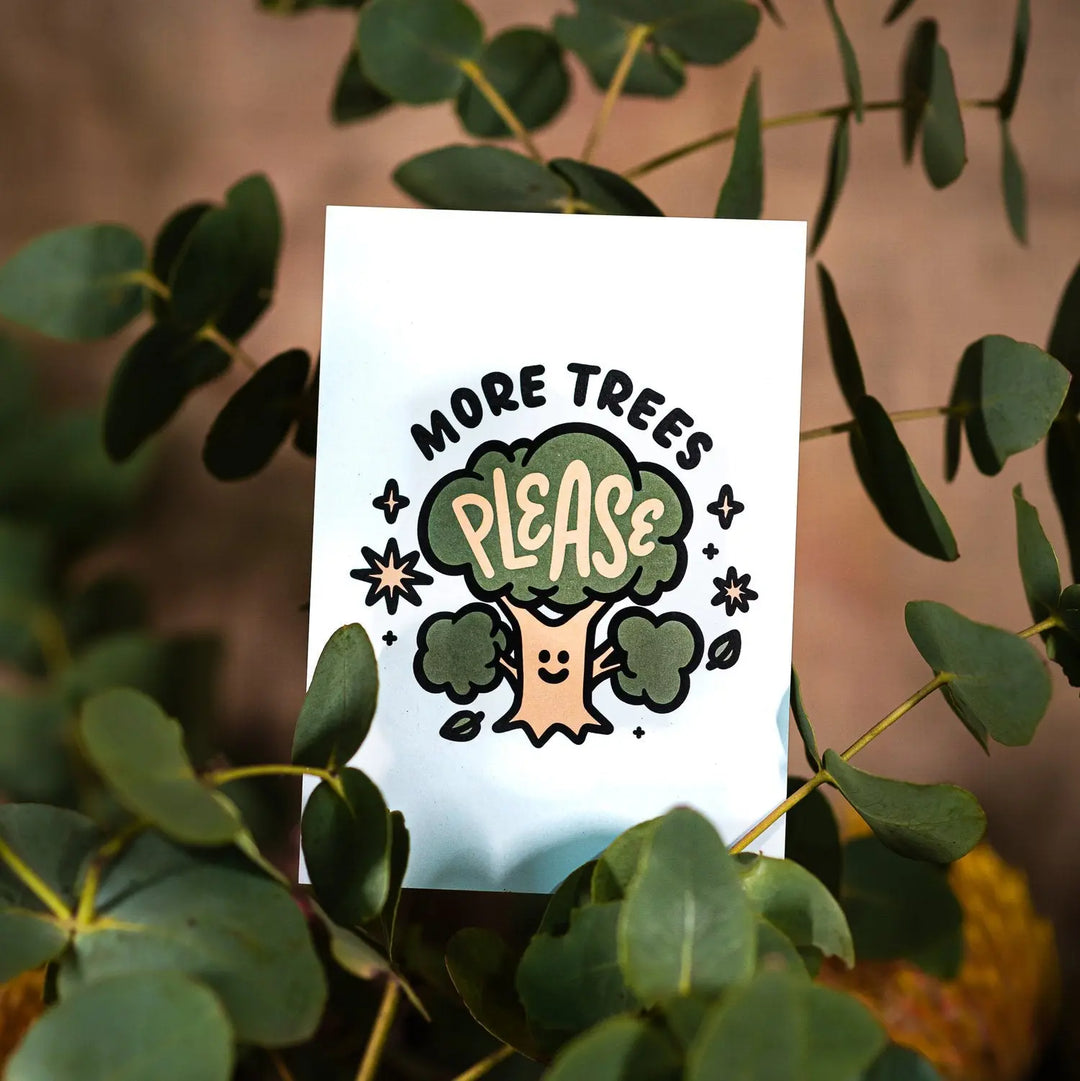 light blue postcard in a eucalyptus branch with cream and green design showing a smiling tree with words more trees please