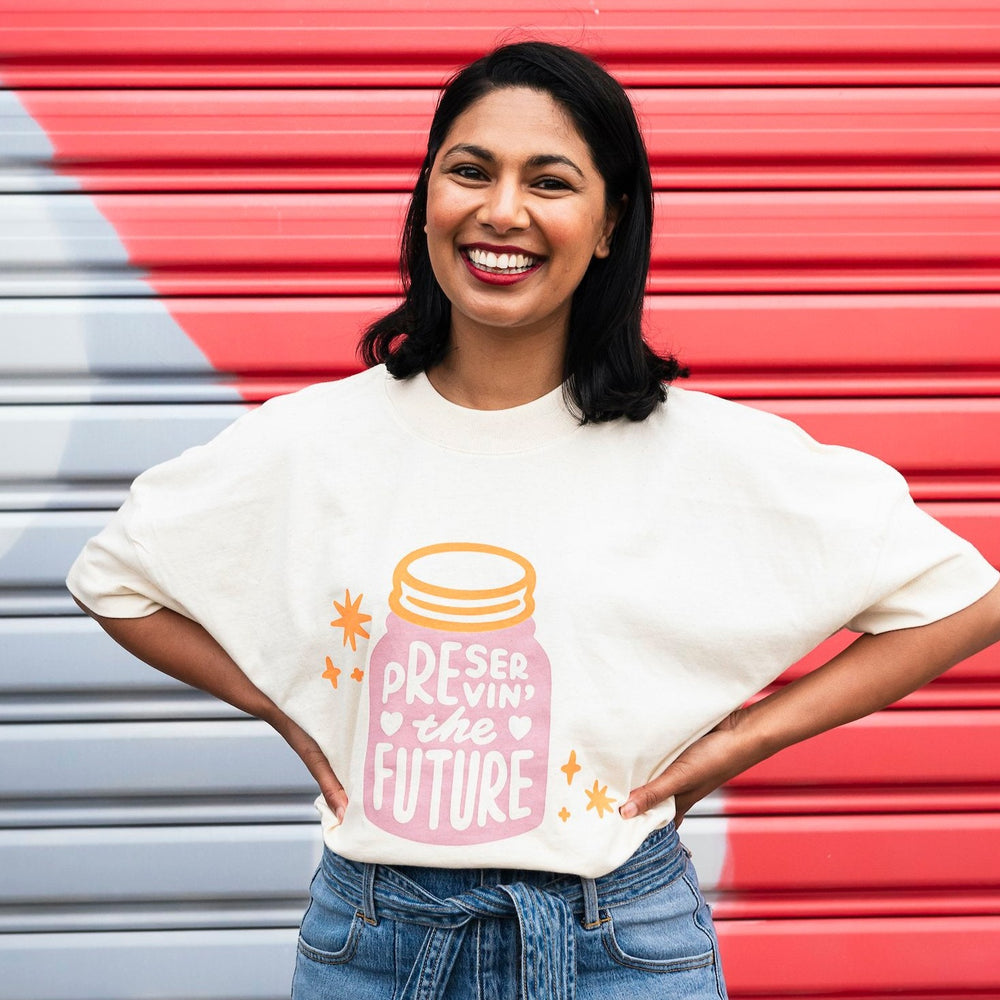 oversized cream organic cotton shirt with pink and orange design of a jar housing the words preserving the future