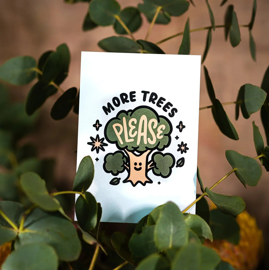 light blue postcard in a eucalyptus branch with cream and green design showing a smiling tree with words more trees please