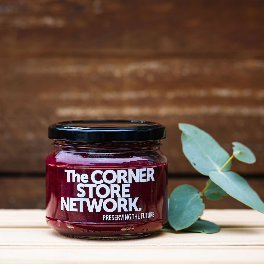 jar of beetroot relish sitting on timber box next to foliage