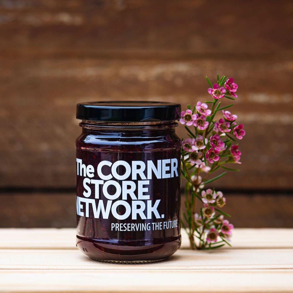 jar of jam made from donated fruit on timber box next to flower