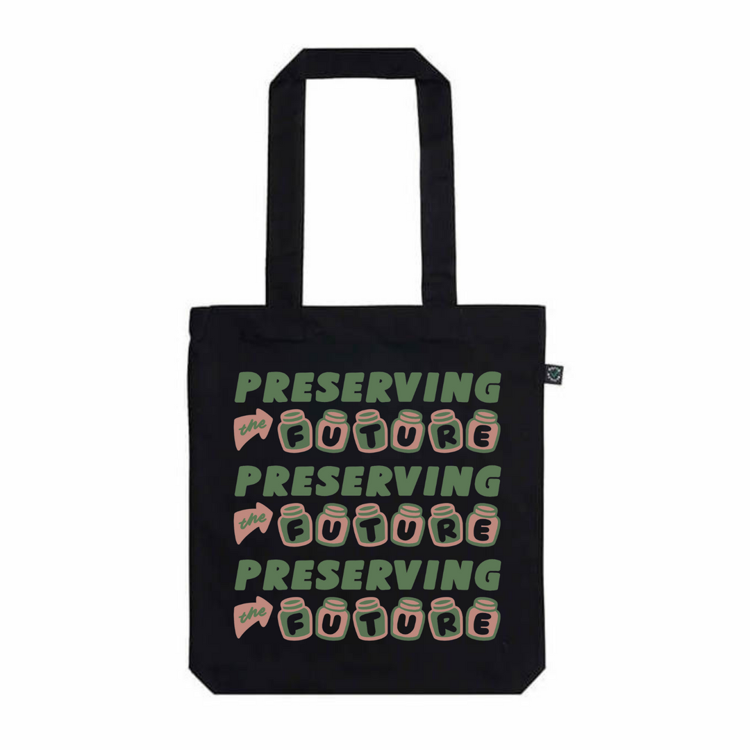 organic black cotton tote with pink and green design with three rows of green and pink text saying preserving the future